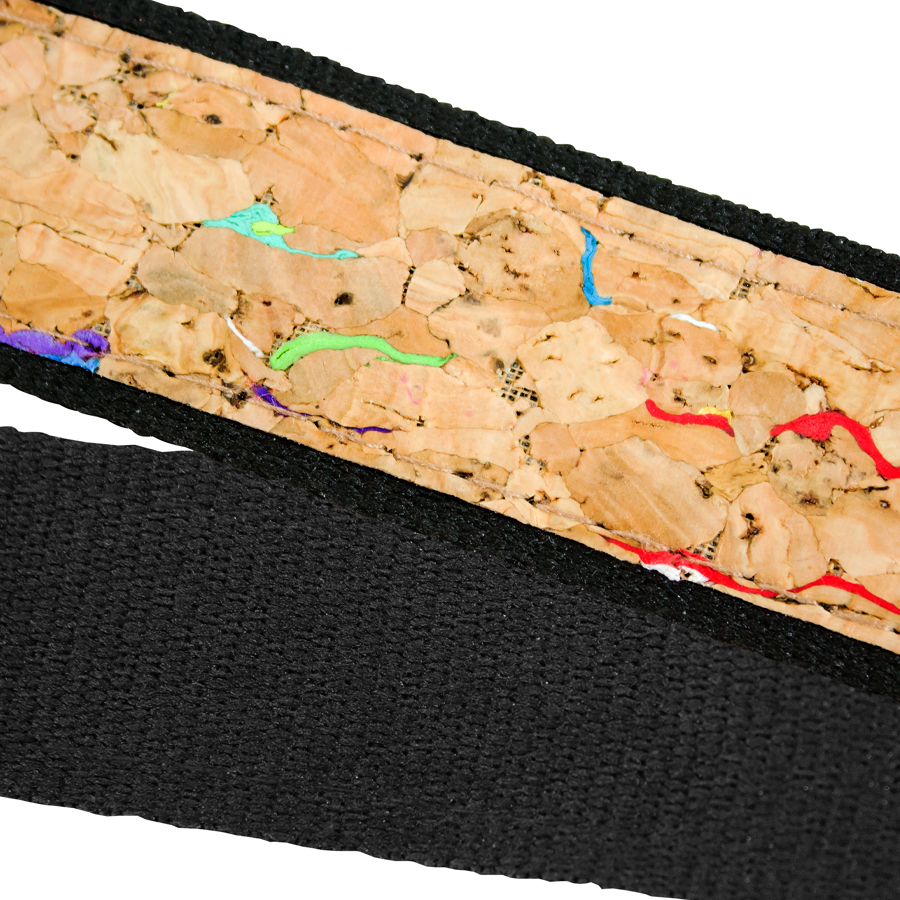 Detalle de un lanyard con textura de corcho natural y costuras negras, mostrando vetas y colores vivos entre las fibras.